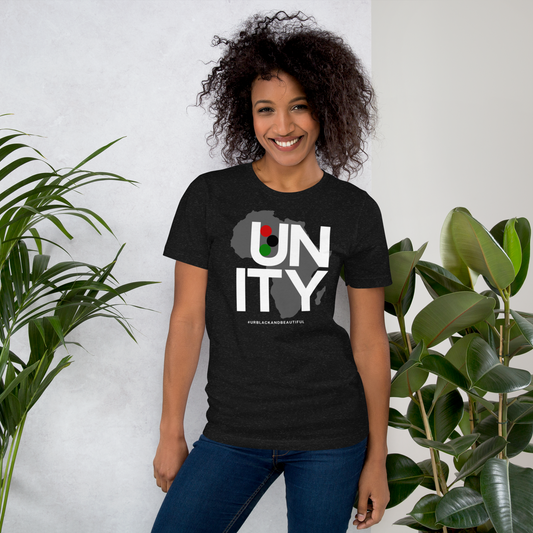 Woman wearing a black t-shirt with 'UNITY' design, standing between two plants.