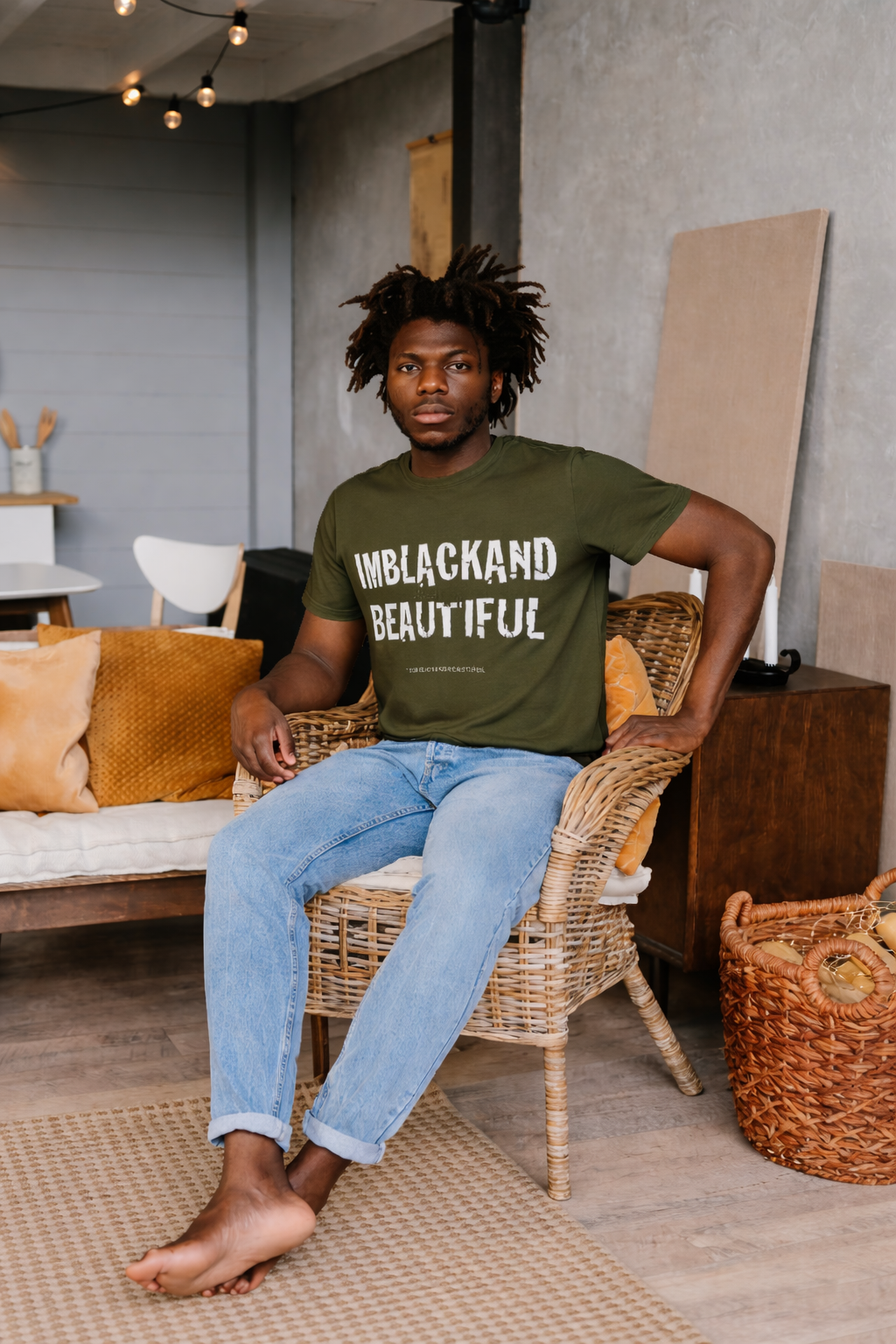 Person sitting on a wicker chair wearing a army green t-shirt with text, in a casual indoor setting.
