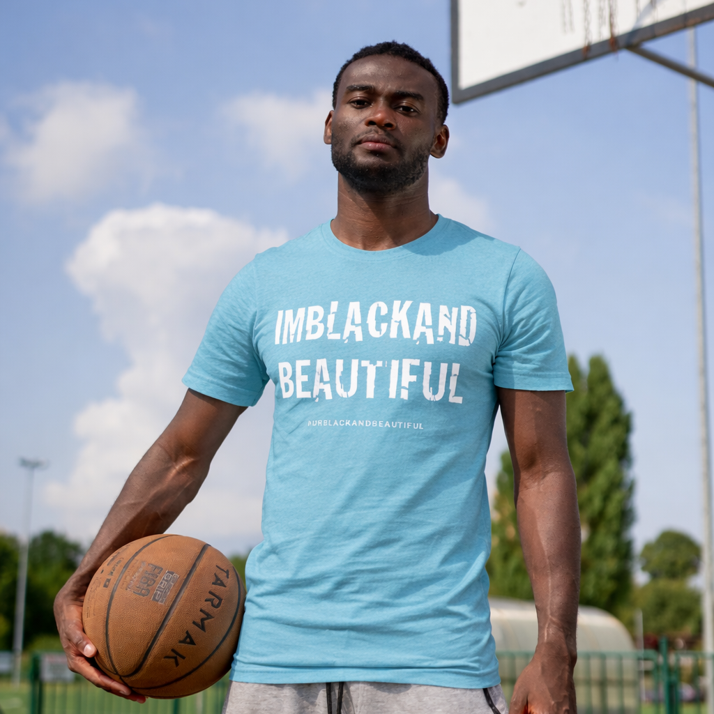 Man holding a basketball on a court wearing a light blue t-shirt with text.