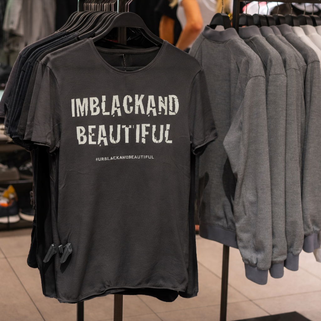 Asphalt color t-shirt with 'IMBLACKANDBEAUTIFUL' text on a clothing rack.