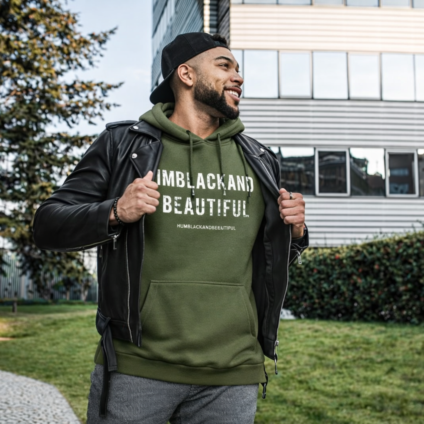 Man wearing a green hoodie with 'IMBLACKANDBEAUTIFUL' text, standing outdoors.
